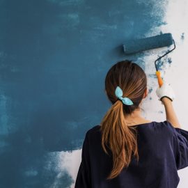 Woman Painting Wall Blue with Roller