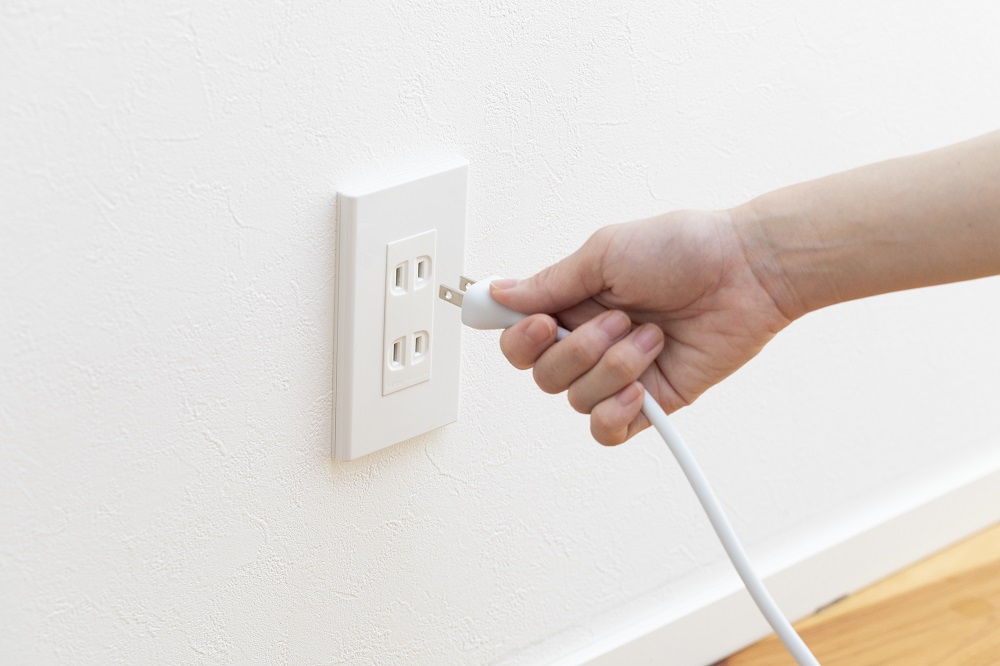 Hand Plugging in Cord in Outlet